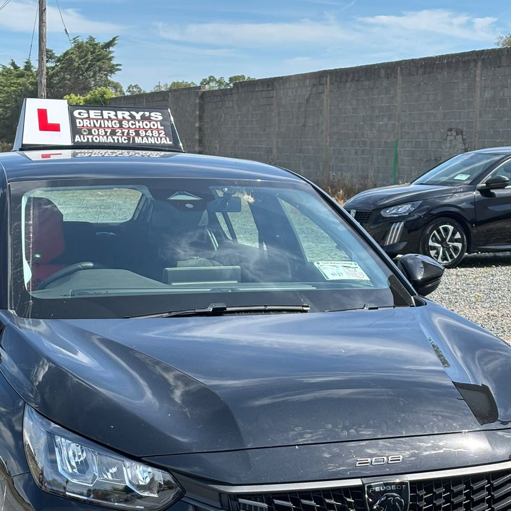The Gerry's Driving School car, a Peugeot 208 with the school's roof sign reading Gerry's Driving School, Automatic / Manual, and a red L-plate